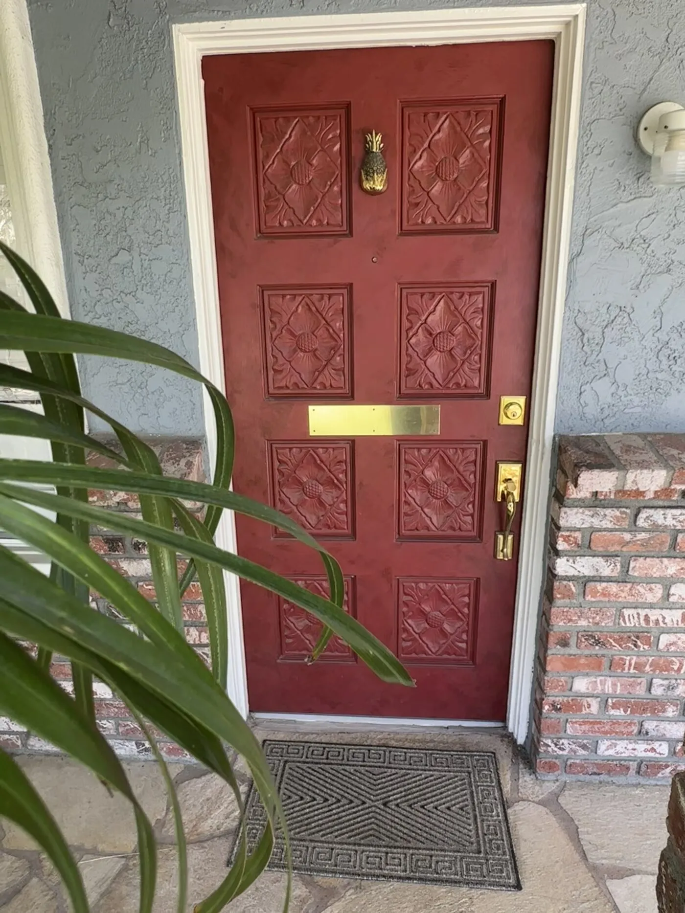 The burgundy front door with its pineapple knocker